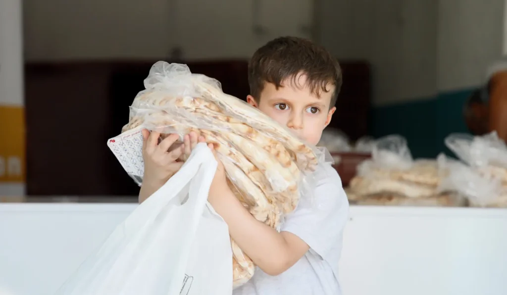 Syria young boy holding bread gaze